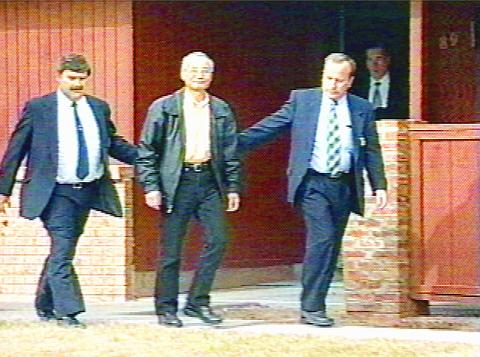 Wen Ho Lee being led by FBI agents after his arrest for the charges under suspicion of downloading and distributing classified material.
