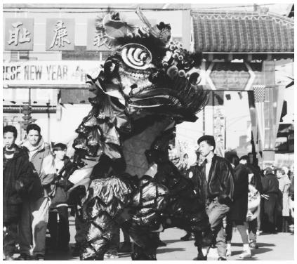 Chinese American performers carring a red and gold dragon while celebrating the Chinese New Year.